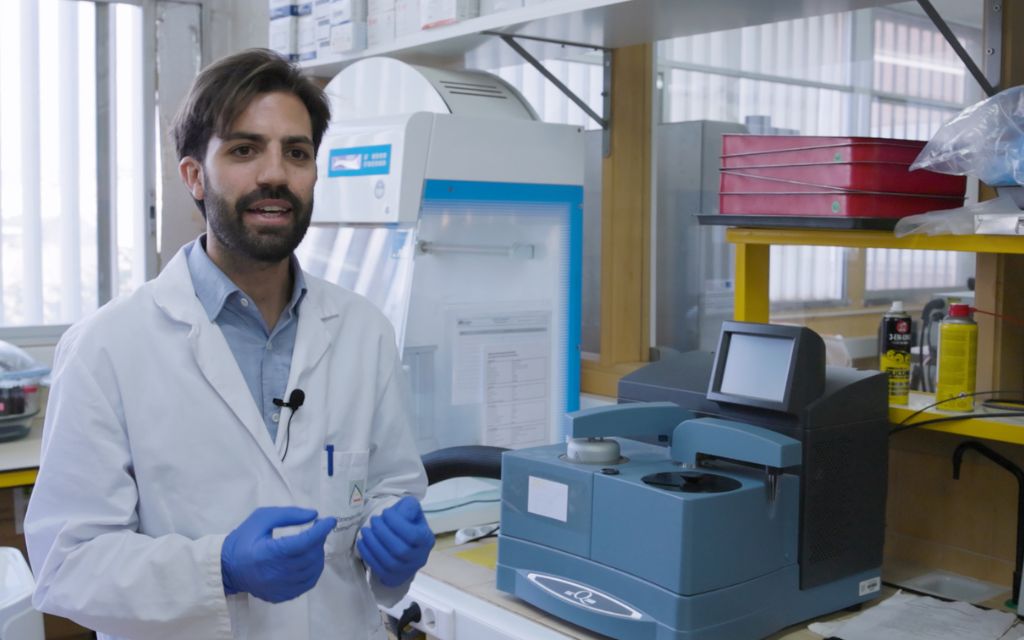 A man in a lab coat is talking at the camera