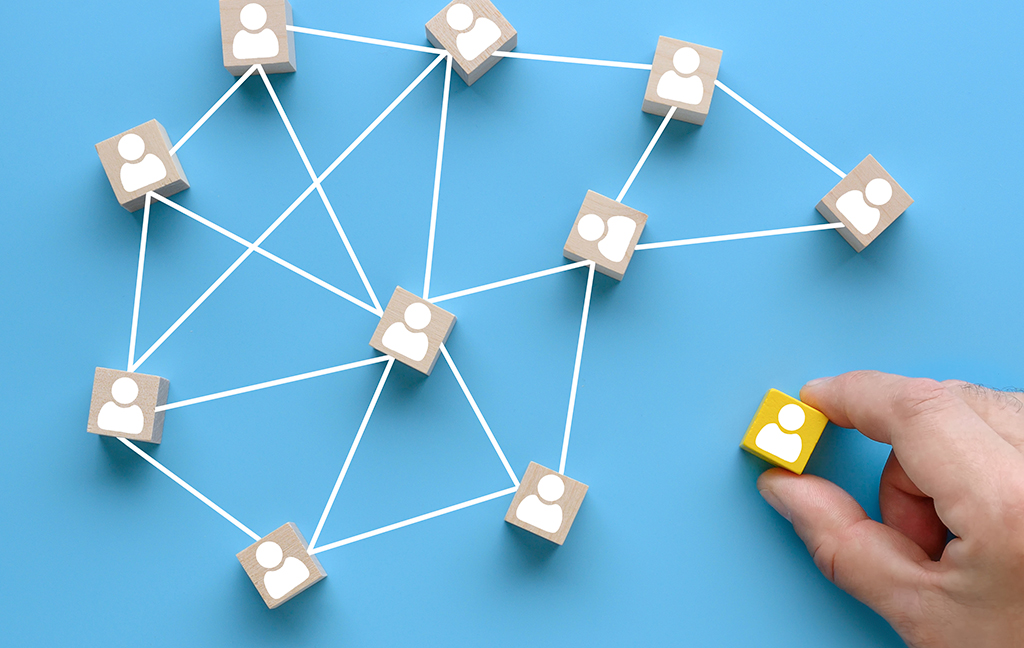 Building a successful team with wooden blocks showing people icons on a blue background, teamwork concept.