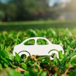 Paper car on grass with a sunny background